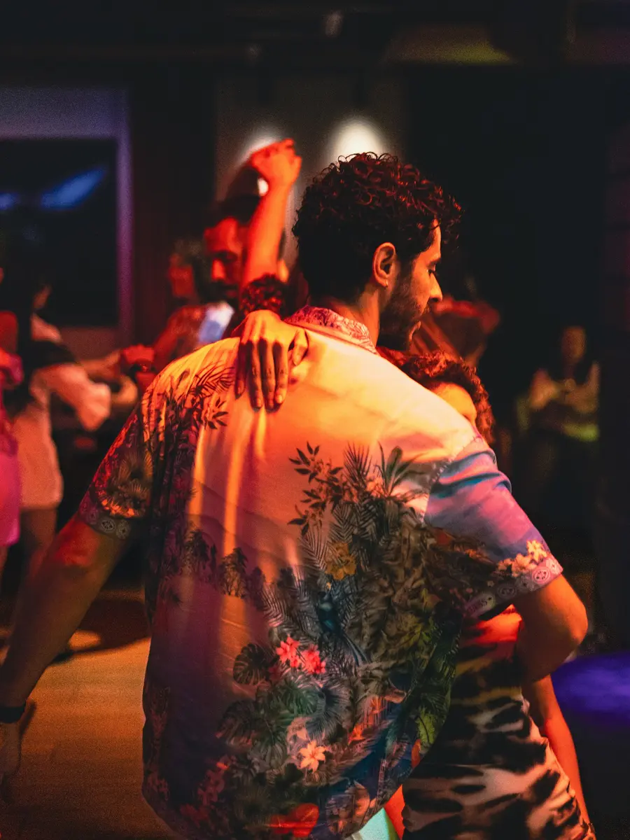 Una pareja bailando en una fiesta con luz tenue
