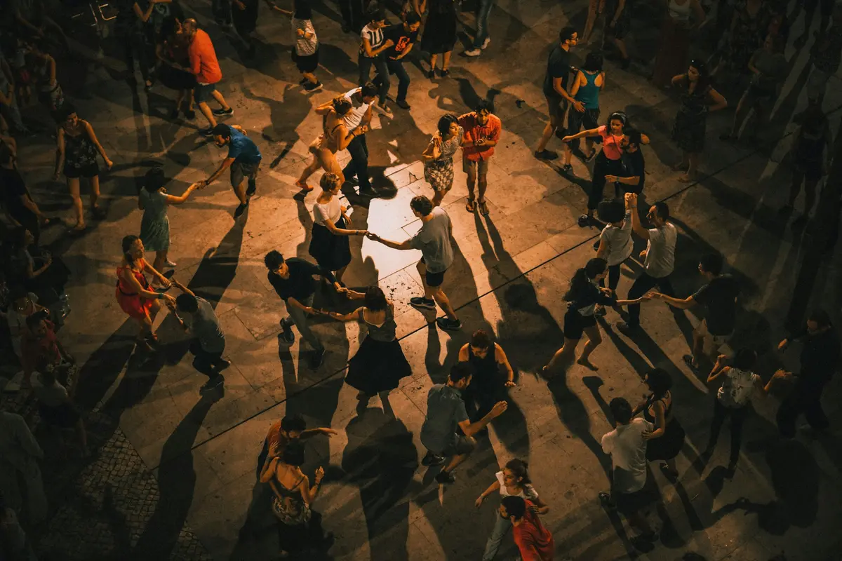 Mucha gente bailando en pareja en una plaza